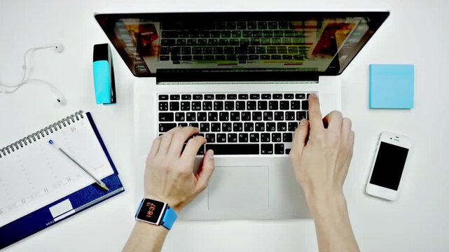 Overhead View of Person Closing Laptop on White Desk