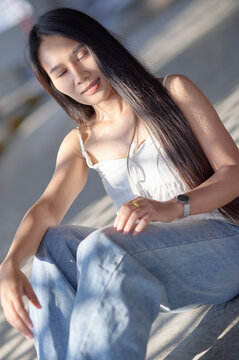 Young woman enjoying sunlight with long hair in casual outfit
