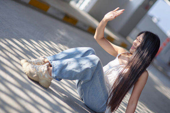 Young woman sitting and waving in a modern urban setting garden