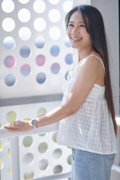 Young Woman Smiling by Window in Bright and Modern Setting