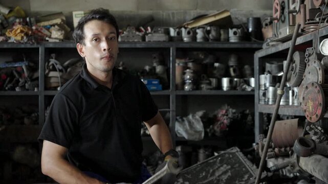 Confident Auto Mechanic Portrait In Engine Parts Storage Room