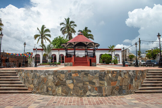 Kiosco en plaza central con plameras y cielo nublado en el fo ndo en el pueblo magico  de Todos Santos Baja California Sur MEXICO.