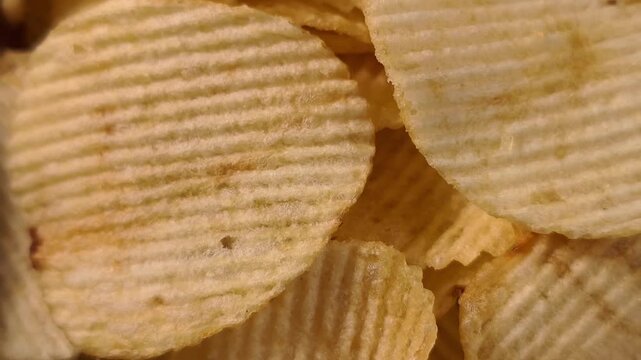 A pile of wavy, ridged potato chips up close
