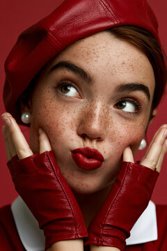 playful freckled woman in red fashion, fair skinned woman with red beret, stylish portrait with playful expression