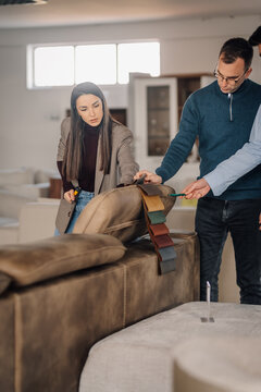 Customers choosing furniture upholstery swatches in showroom