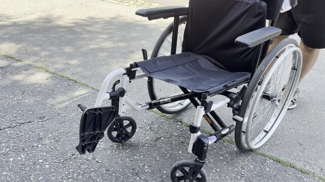 Empty wheelchair outdoors on paved path