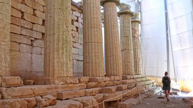 Young woman tourist visiting ancient Bassae Greece archaeological site
