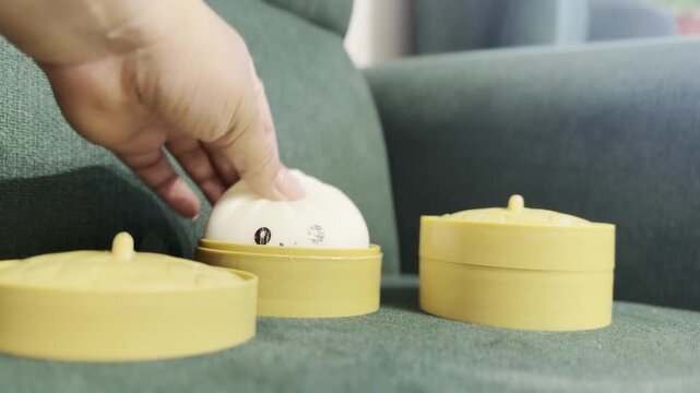 Hand touching a cute smiling squishy toy squishy Rainbow Mystery Bun