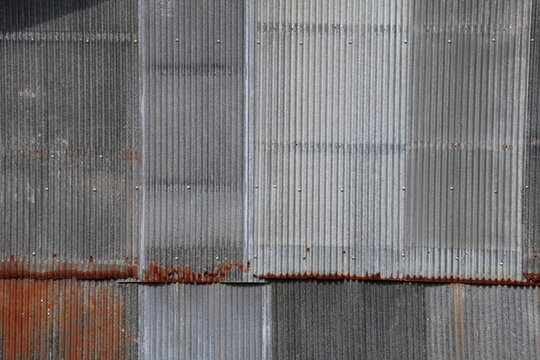 Artistic of old and rusty zinc sheet wall. Vintage style metal sheet roof texture. Pattern of old metal sheet. Rusting metal or siding. Corrosion of galvanized. Background and texture in retro concept