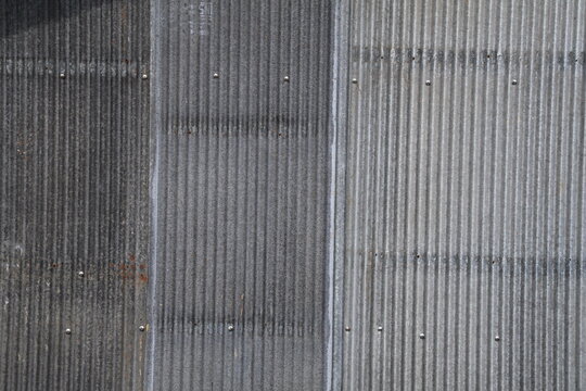 Artistic of old and rusty zinc sheet wall. Vintage style metal sheet roof texture. Pattern of old metal sheet. Rusting metal or siding. Corrosion of galvanized. Background and texture in retro concept