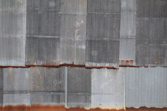 Artistic of old and rusty zinc sheet wall. Vintage style metal sheet roof texture. Pattern of old metal sheet. Rusting metal or siding. Corrosion of galvanized. Background and texture in retro concept