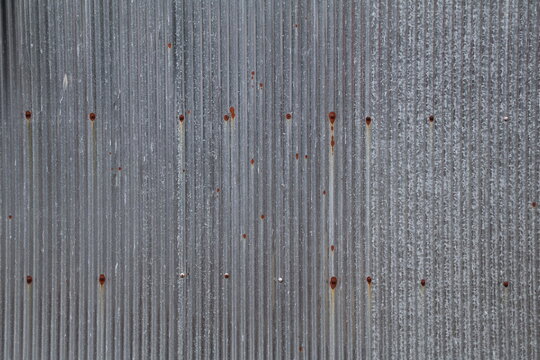 Artistic of old and rusty zinc sheet wall. Vintage style metal sheet roof texture. Pattern of old metal sheet. Rusting metal or siding. Corrosion of galvanized. Background and texture in retro concept