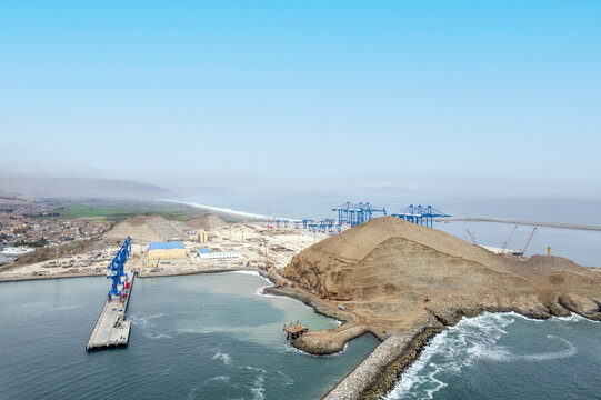 Chancay, Lima Region, Peru - 28 August 2024: Aerial view of the Port of Chancay under construction, featuring large cranes, breakwaters, and coastal infrastructure.