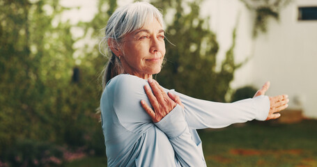 Obraz na płótnie Canvas Backyard, wellness and senior woman stretching for functional fitness, shoulder mobility or exercise. Active, pensioner or arm warm up at house for retirement health, physical activity or flexibility