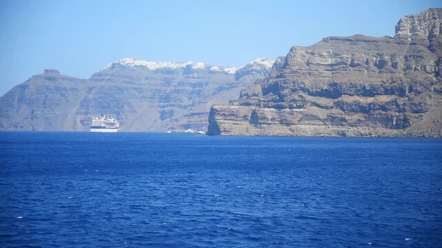 Cruise ship sailing the Aegean Sea approaching Santorini island, Greece