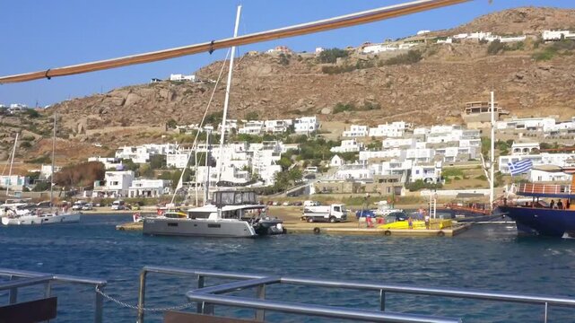 Greek flag waving on a boat in Mykonos harbor