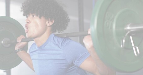 Obraz premium Man bracing core and inhaling, initiating back squat for fitness with barbell, green plates, rack