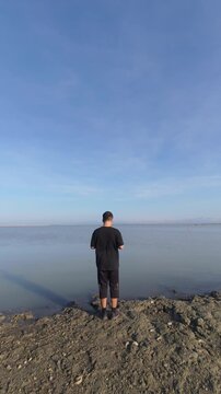 Man Standing by the Water