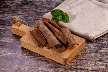 Cinnamon sticks on wooden cutting board with mint leaf © Andrei Starostin