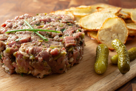 A closeup view of steak tartare and homemade potato chips.