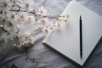 Cherry blossom branch lying on blank notebook with a pencil, conveying creativity and spring © juliars