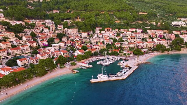 Brela Croatia shows marina, beach, buildings, and coastal area with boats and trees during daytime