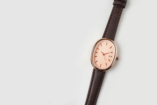 Elegant Rose Gold Oval Wristwatch with Brown Leather Strap on White Minimal Background