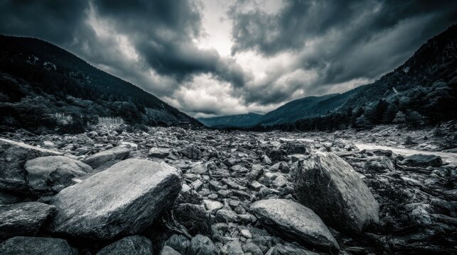 Stormy valley floor strewn with massive boulders and rock fragments under dramatic, cloudy skies