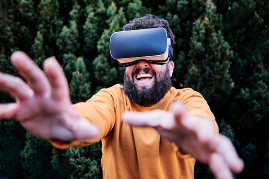 Playful man using VR glasses in garden