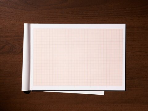 Blank graph paper pad on a dark wooden table indoors