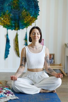 Yoga teacher practicing meditation indoors for mental health