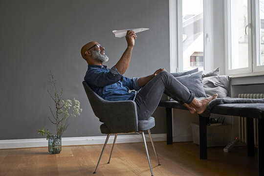 Mature man plying with paper plane