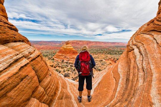 USA, Arizona, Page, Paria Canyon, Vermillion Cliffs Wilderness, Coyote Buttes, tourist enjoying the view on red stone pyramids and buttes