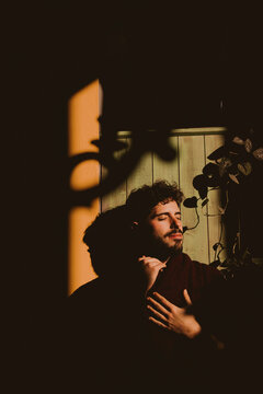 Moody portrait of a man with dramatic shadows and warm sunlight
