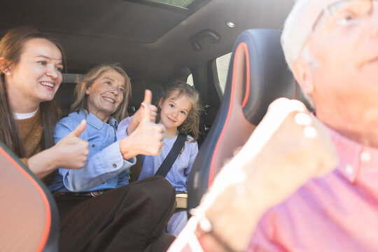Happy family showing approval during a road trip in a car