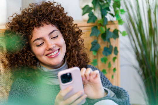 Smiling freelancer using smartphone at home