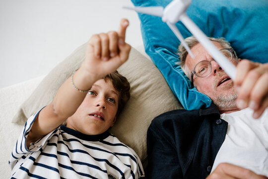 Father explaining wind energy to son using a model at home