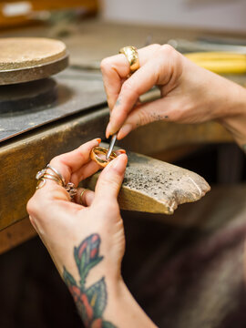 Hands of goldsmith making ring with work tool at workshop