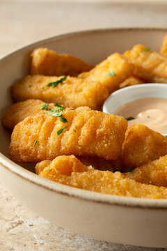 A closeup view of a bowl of dairy-free, gluten-free breaded fish sticks.