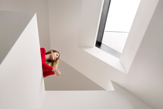 Young woman on upper floor under roof window