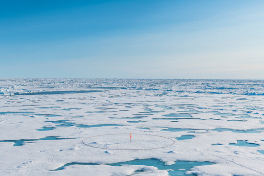 Aerial view of round marker set up on melting ice at North Pole