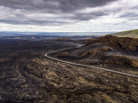 Lonely gravel road through ancient lava field in Iceland