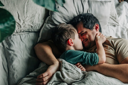 Smiling man with boy sleeping in bed