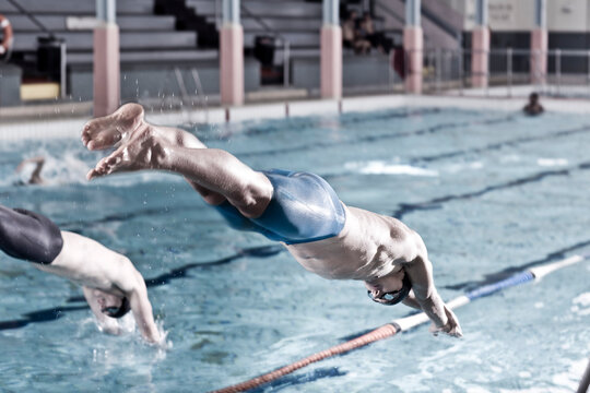 Two swimmers in indoor pool starting