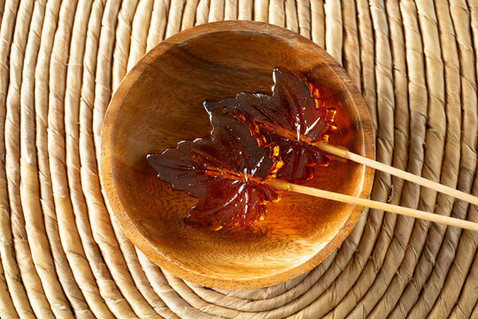 A top down view of some maple leaf hard candy lollipops.