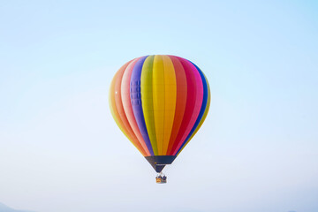 Fototapeta premium Colorful hot air balloon flying in a clear blue sky