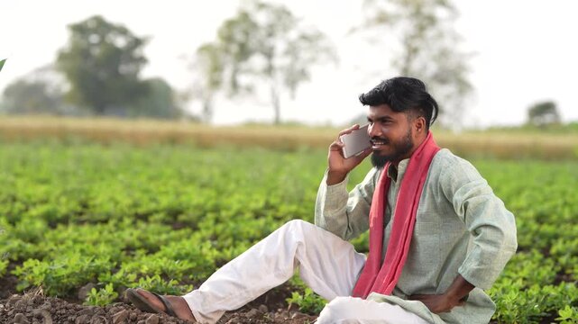 Indian farmer using smartphone at agriculture field 