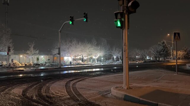 Green traffic light in pedestrian crosswalk signal of intersection in urban cityscape public safety of transportation mobility commute in Tehran Iran nighttime illuminated peaceful winter snowfall