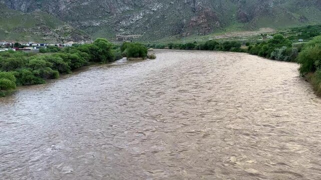 Aras River in border frontier of Iran Armenia Caucasus transboundary waterway agriculture irrigation in farmland rural landscape nature scenic riverbank freshwater valley mountains panoramic summer