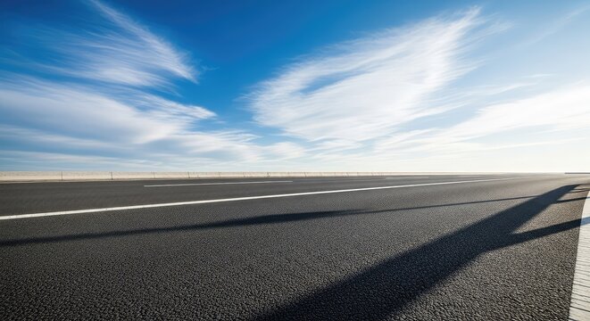 An empty asphalt highway stretches toward a bright blue horizon under a vast sky filled with soft white clouds on a sunny, clear day, asphalt, summer, outdoor